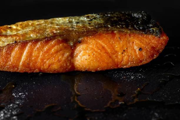 Grilled salmon steak on dirty black.