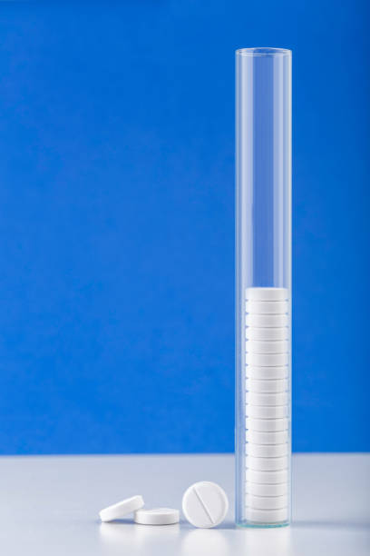 Bunch of white pills with glass ampoules. Test-tube with medicament.