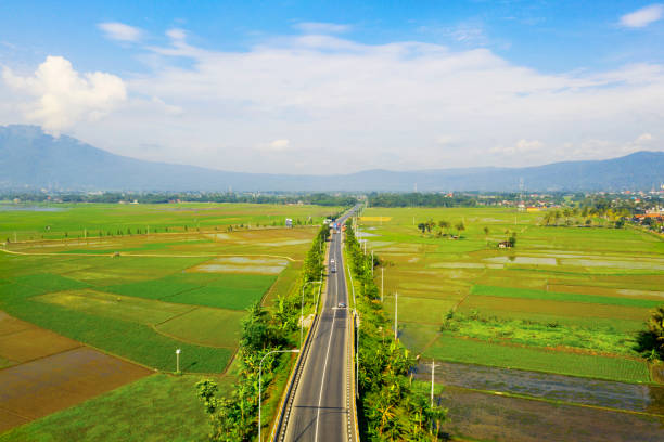Beautiful trans-Java Toll Road in middle of farmland Aerial view of beautiful trans-Java Toll Road in middle of farmland at sunny day in Semarang, Indonesia central java province photos stock pictures, royalty-free photos & images