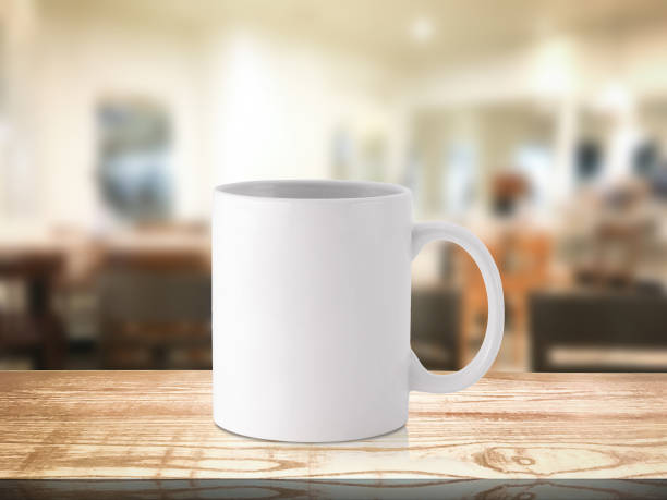 istock White coffee mug or drink cup on blur restaurant or desserts cafe interior store background. Wooden shelf backdrops with mugs for design. 1164099620