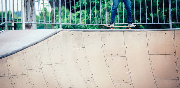 istock Skateboarder skateboarding at skatepark ramp 1164099660