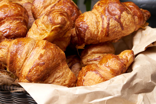istock Croissants in a wicker basket on the counter, fresh croissants 1164100942