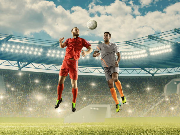два исповедальных футболиста борются за мяч в воздухе - kick off soccer player soccer kicking стоковые фото и изображения