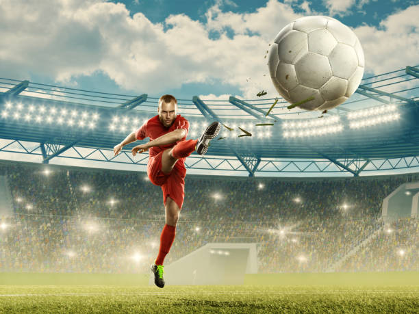 футболист пинает мяч. спортивный стадион с трибунами и подсветкой - kick off soccer player soccer kicking стоковые фото и изображения