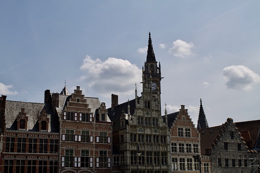 Facade of old houses of Ghent with in background the bell tower of the church of saint Nicolas