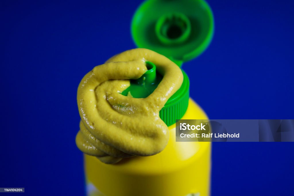 Nahaufnahme von Paste von Senf ausgepresst eine Plastikflasche mit blauem Hintergrund - Lizenzfrei Röhrenform Stock-Foto Nahaufnahme von Paste von Senf ausgepresst eine Plastikflasche mit blauem Hintergrund - Lizenzfrei Röhrenform Stock-Foto