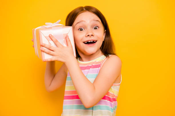 Portrait of lovely child holding present for 8-march screaming wow omg isolated over yellow background Portrait of lovely child holding present for 8-march screaming wow omg isolated, over yellow background little redhead girl stock pictures, royalty-free photos & images