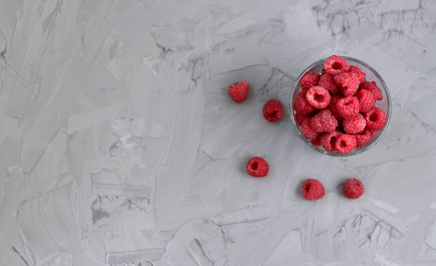 istock ripe juicy raspberry in a glass. 1164107141