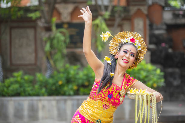 istock Beautiful Balinese dancer throws frangipani flowers 1164108464
