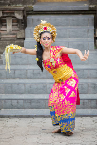 istock Female Pendet dancer carries flower petals 1164108506