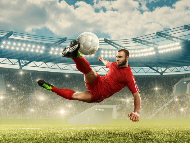 calciatore che calcia una palla in aria - kick off soccer player soccer kicking foto e immagini stock