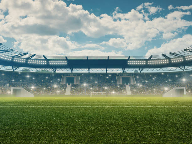 stadio di calcio con tribune, illuminazione, erba verde e cielo azzurro nuvoloso - campo da calcio foto e immagini stock