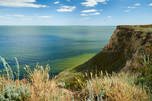 Wild sea coast, wave and hill - beautiful summer landscape and travel concept, bright day and sky with clouds.