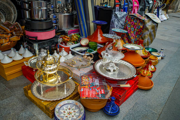 Bordeaux, France. Lots of different items on the sidewalk outside a store in Nice, France. There are a variety of bric a brac items including gingham tablecloths and printed napkins as well as crockery and trays.