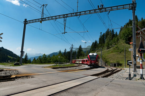 trem estreito vermelho do calibre chega em uma estação de trem remota nos alpes suíços - rhätische bahn - fotografias e filmes do acervo