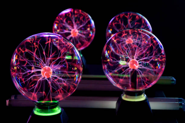 istock Close-Up Of Illuminated Plasma Balls On Table Against Black Background 1164114963