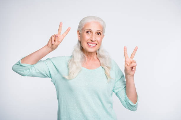 istock Portrait of adorable lady making v-signs looking wearing teal pullover isolated over white background 1164117121