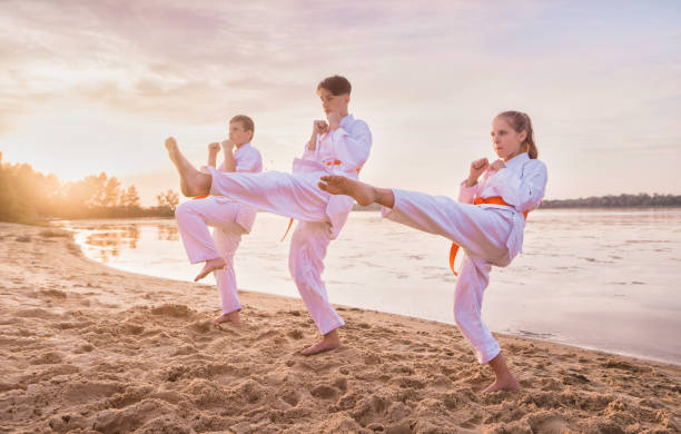 istock group of kids training karate martial arts on sunset beach 1164120413