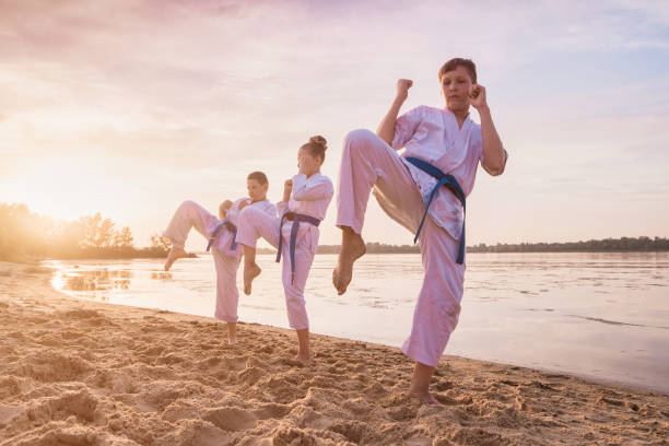 istock group of kids training karate martial arts on sunset beach 1164120426