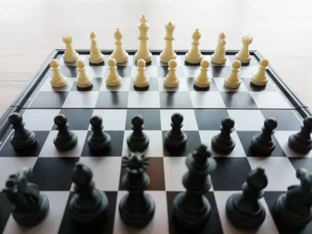Photo of black and white chess on wooden table