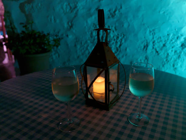 istock Two white wine glasses on the table illuminated by candle lantern with blurred wall on the background in La Era restaurant in Yaiza Lanzarote 1164128956