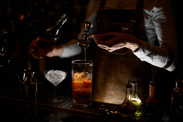 bartender pouring alcohol cocktail using jigger with handle - men elegance cocktail cool imagens e fotografias de stock