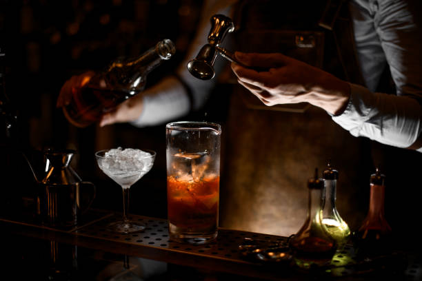 bartender pours alcohol cocktail using jigger with handle - men elegance cocktail cool imagens e fotografias de stock