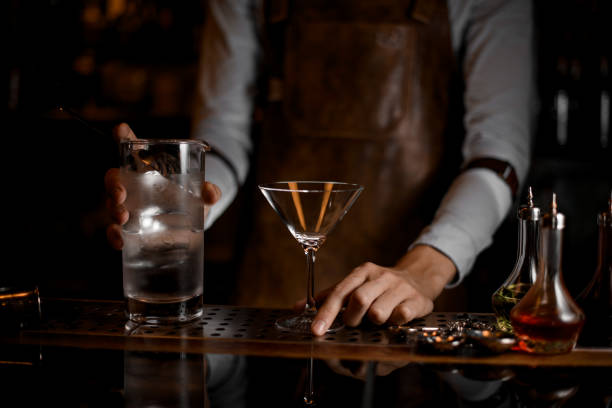 istock Bartender prepares to pour a martini cocktail 1164131043