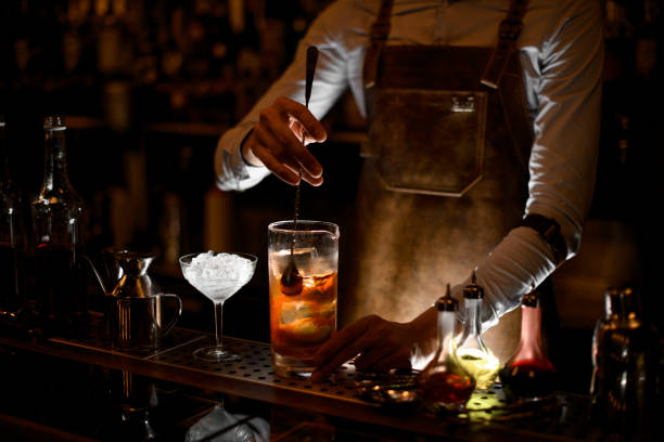 istock Bartender stirs alcohol cocktail with the spoon 1164131132