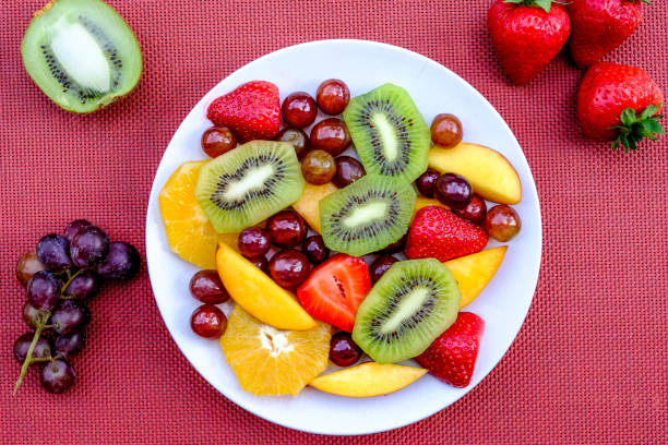 postre de ensalada de verano de frutas frescas con naranjas, fresas, melocotones de frutas kiwi y uvas - fruit salad freshness strawberry fotografías e imágenes de stock