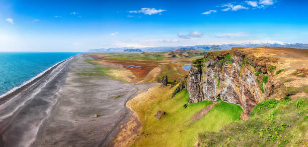 View of Kirkjufjara black sand beach from Dyrholaey promontory on Atlantic South Coast.\