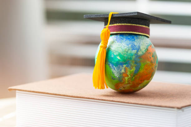 istock Education to learn study in world. Graduated student studying abroad international idea. Master degree hat on top globe book. Concept of graduate educational for long distane learning anywhere anytime 1164140349