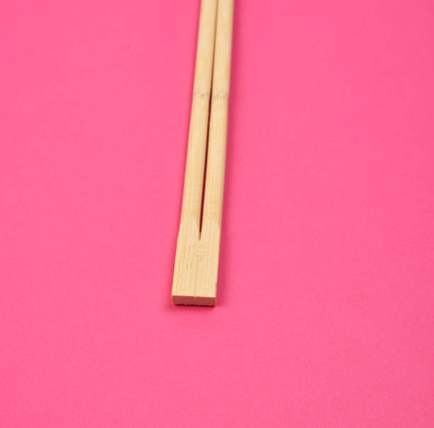 istock two wooden chopsticks on a pink background 1164140944
