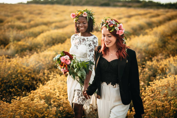 istock Two lesbian brides walking in the flower field 1164144948