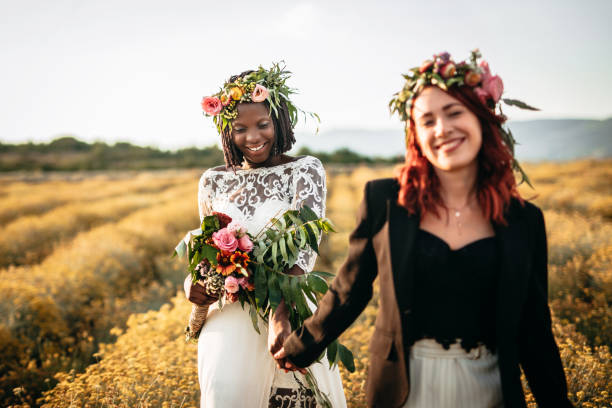 istock Two lesbian brides walking in the flower field 1164145211
