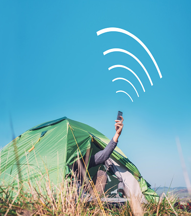 Traveler sits in touristic tent and try to catch cellular network