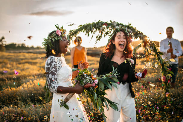 Ready for wedding party Lesbian wedding party. Two brides on wedding ceremony, surprised with confetti standing in a front of outdoor wedding arch altar photos stock pictures, royalty-free photos & images