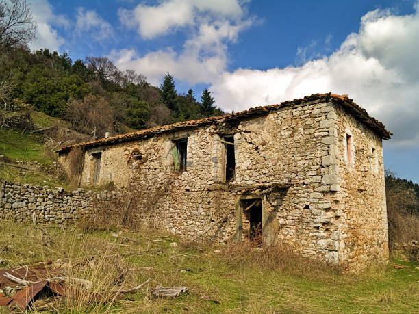 istock Abandoned ruined village house under blue sky with clouds. 1164146666