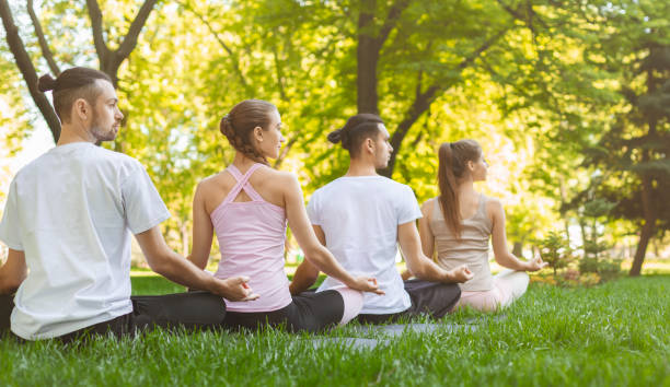 istock Four friends enjoying morning meditation in park 1164147722