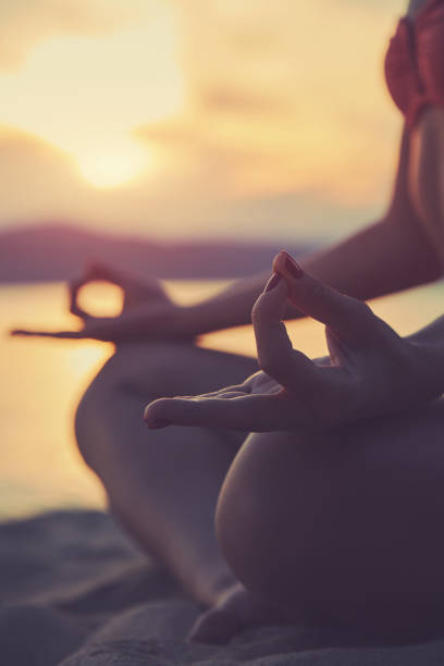 istock Young woman practicing yoga on the sandy beach. 1164147727