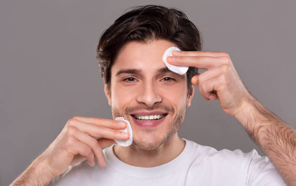 istock Handsome man cleaning face skin with cotton pads 1164147924