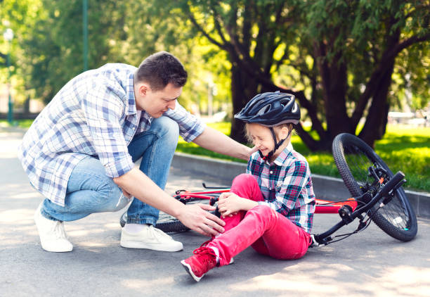 le père réconforte sa fille après être tombé du vélo - child bicycle cycling danger photos et images de collection