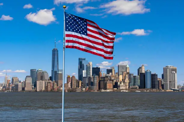 Photo of Scene of Flag of America over New york cityscape river side which location is lower manhattan,Architecture and building with tourist and Independence day concept