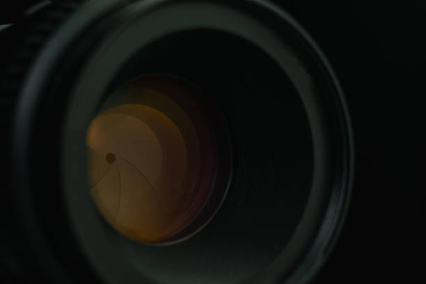 istock Close up camera aperture lens with yellow glass reflection. Macro view. 1164149731
