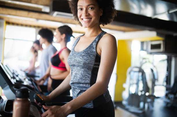istock Group of sportive people in a gym training 1164149995