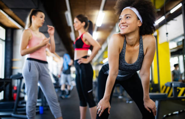 istock Group of sportive people in a gym training 1164151193