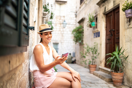 Young beautiful woman using phone in Croatian street