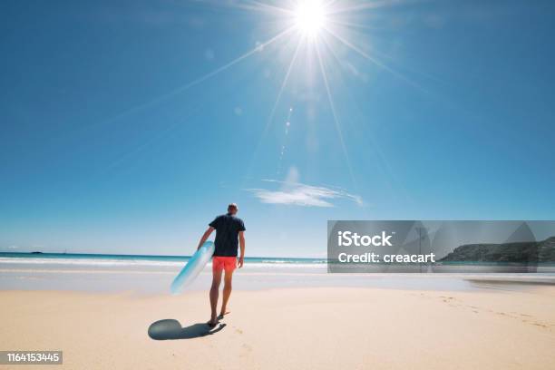 Man Walking Towards The Waters Edge Of The Pristine Pedn Vounder Beach Cornwall On A Hot Sunny June Day Stock Photo - Download Image Now