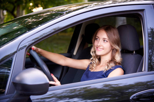istock Happy young woman in a black auto. 1164154401