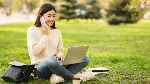 istock Relax after classes. Happy student sitting in park with laptop 1164159209